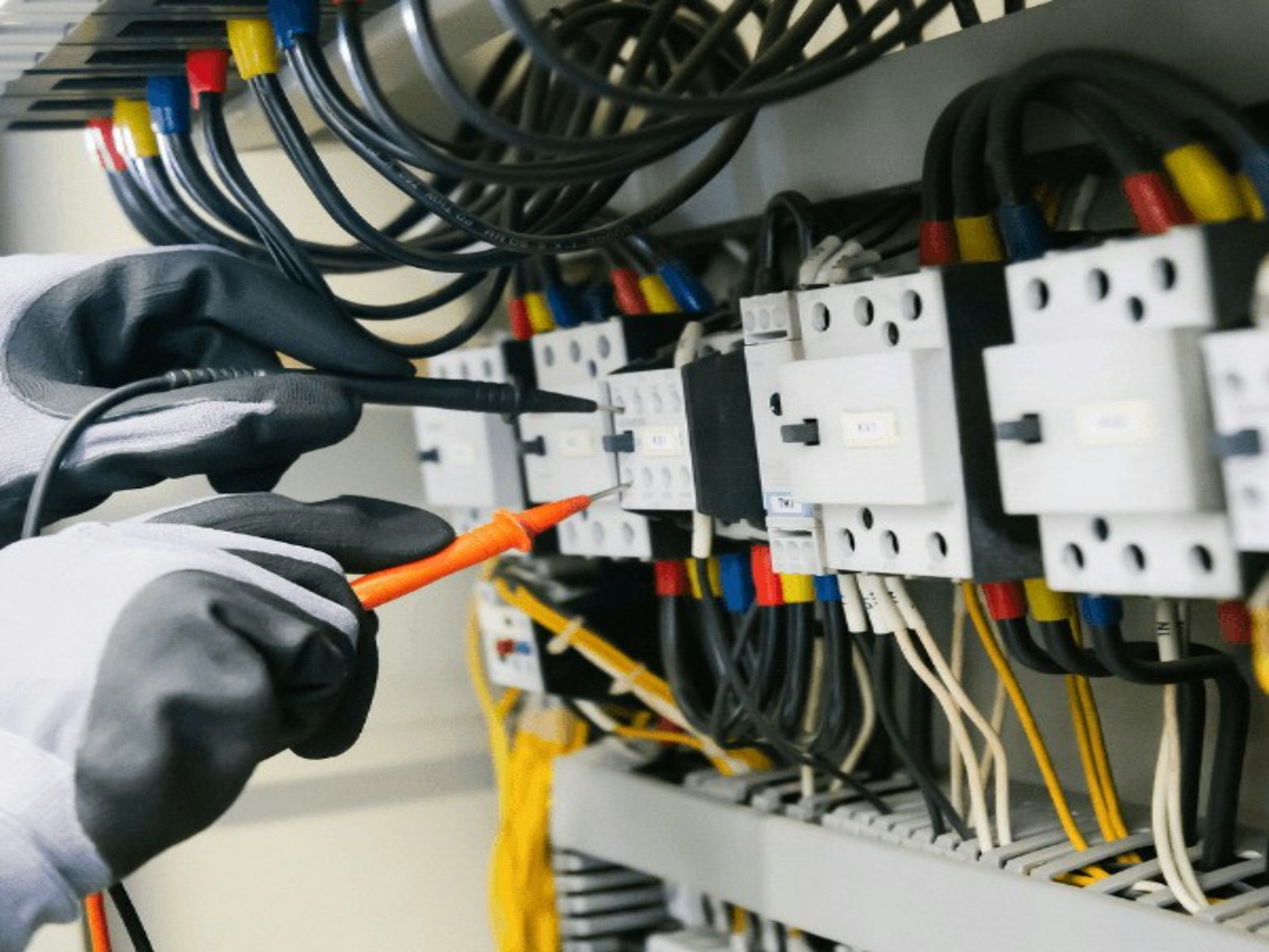 Manos conectando cables en un tablero