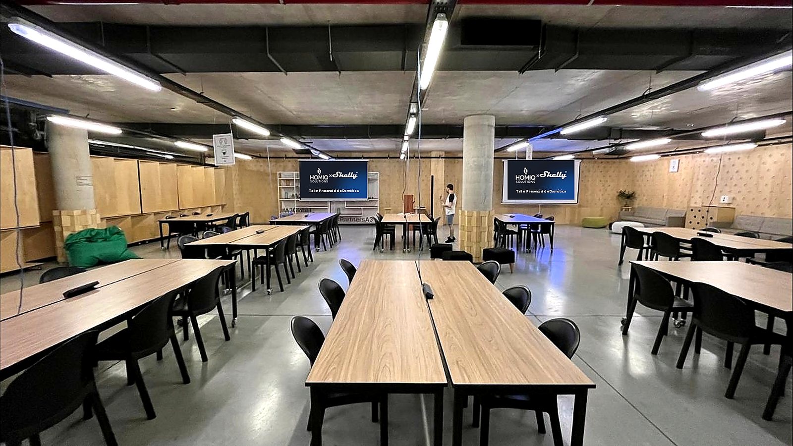 El salón con las mesas de trabajo y las pantallas HOMIQ × Shelly